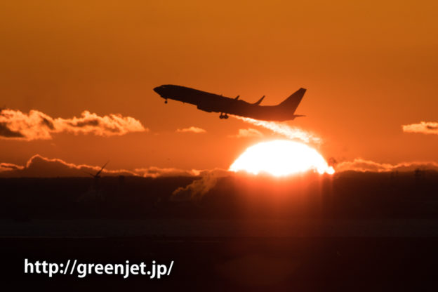 羽田空港にて朝焼けの空と離陸する飛行機