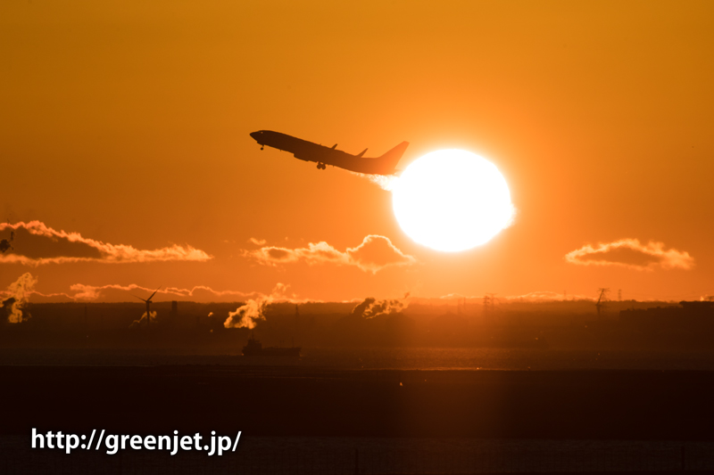 羽田空港にて朝焼けの空と離陸する飛行機